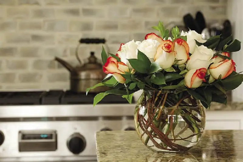 flowers in a glass jar on the kitchen countertop