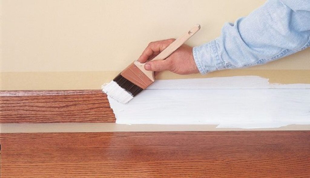 applying primer to baseboards