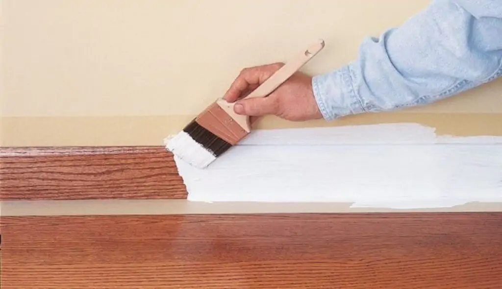 applying primer to baseboards