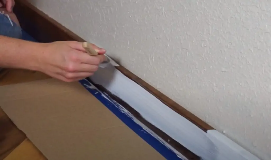 applying paint to baseboards
