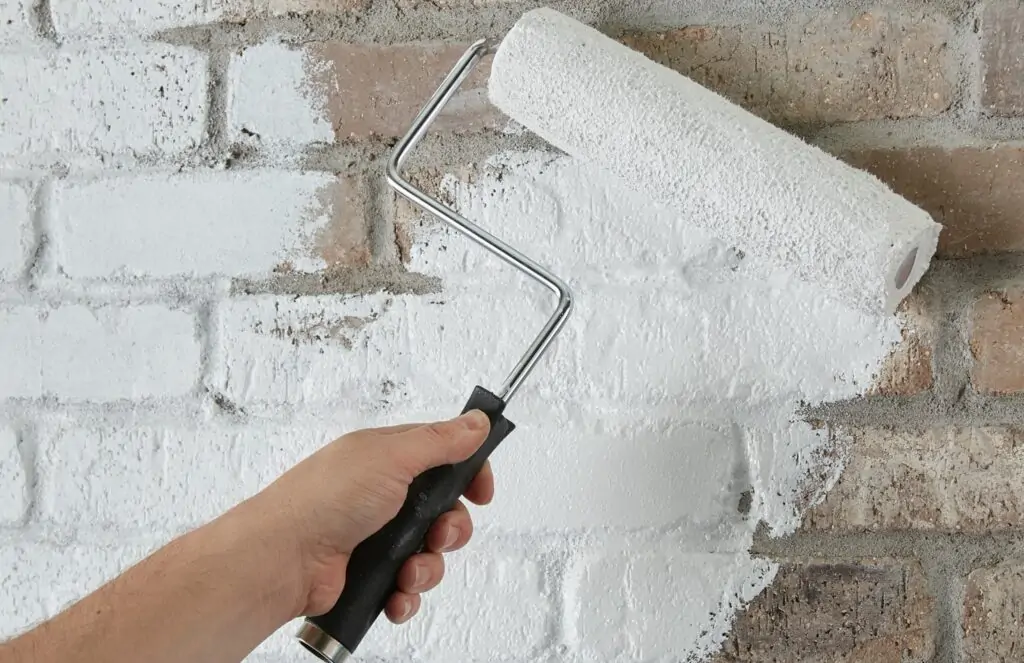 applying primer to brick fireplace
