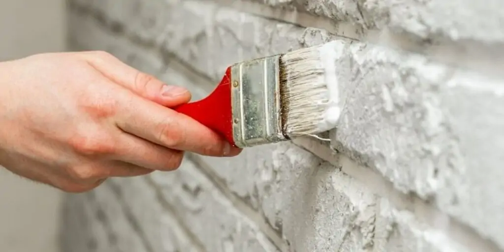 applying paint to brick fireplace