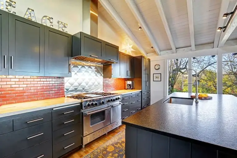 modern kitchen with grey cabinets and small brick backsplash