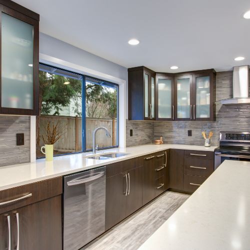 Discreet brown kitchen cabinets in kitchen with large window