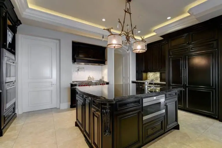 beautiful black cabinet kitchen with granite counter and white subway tile