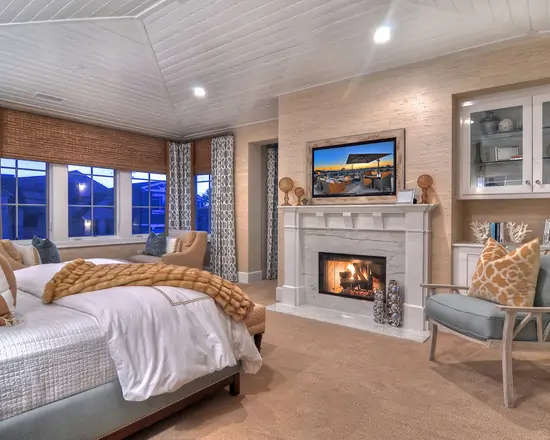luxury master bedroom with sitting area tv and fireplace