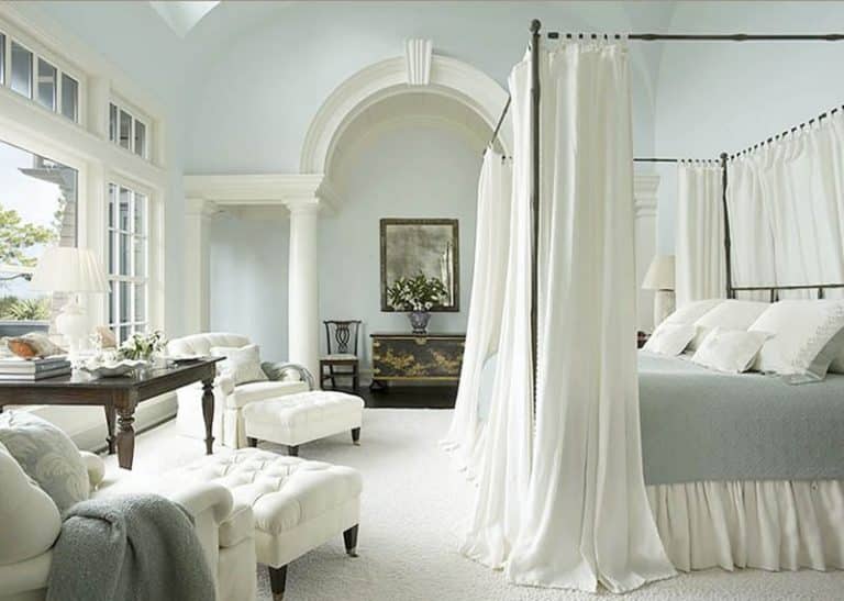 classic master bedroom with sofa chairs and foot stools