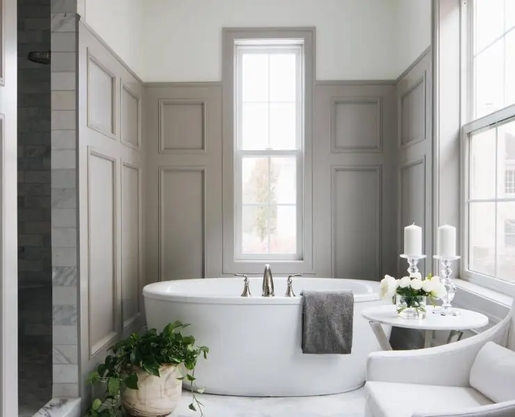 Candles and green plants beside bath tub